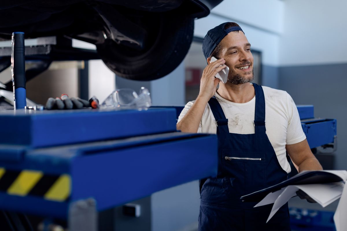 Happy professional mechanic working in modern truck repair facility, demonstrating the positive work environment and career opportunities at Truck Technics